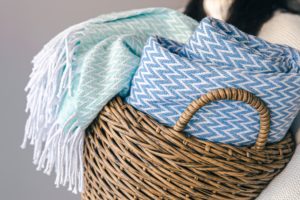 Wełniane szaliki w wiklinowym koszu.